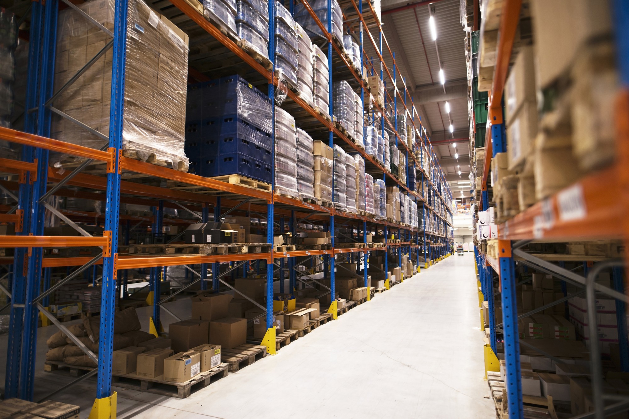 interior del gran almacen de distribucion con estantes apilados con paletas y productos listos para el mercado